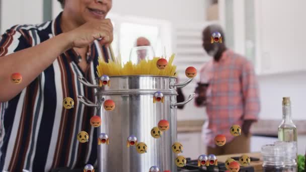 Multiple Face Emojis Floating African American Senior Woman Cooking Spaghettis — Stock Video