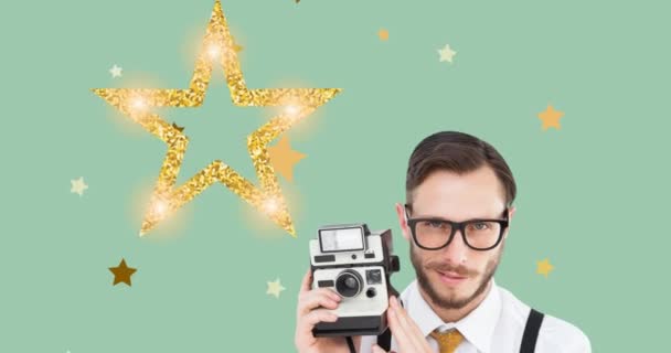 緑の星とクリスマスの装飾の上に移動レトロなカメラを保持する笑顔の男のアニメーション ヴィンテージのお祝いとお祭りのコンセプトデジタル生成されたビデオ — ストック動画