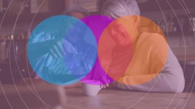 Afrikalı Amerikalı kıdemli bir adamın karısı için kahve doldurmasına karşı renkli dairesel şekiller. emekli çift yaşam tarzı konsepti