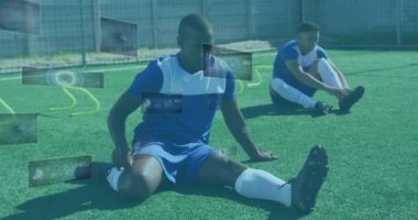 Erkek futbolcuların esneme hareketleri üzerine ekranlardaki dürbün ve veri işleme animasyonları. global spor, teknoloji ve dijital arayüz kavramı dijital olarak oluşturulmuş video.