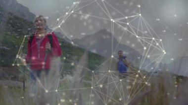 Mutlu Kafkas kıdemli çiftler kırsal kesimde yürüyüş yapıyor, iletişim ağı üzerinden. aktif açık hava yaşam tarzı, sağlıklı emeklilik ve küresel iletişim konsepti, dijital olarak oluşturulmuş video.