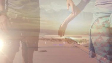 Bulutların üzerinde deniz kenarında el ele tutuşan beyaz bir çiftin orta kesimi. Aktif açık hava yaşam tarzı, sağlıklı emeklilik ve özgürlük konsepti, dijital olarak üretilen video. ve gün batımı