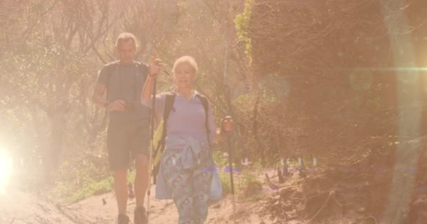 田舎のハイキングで白人のシニアカップル レンズフレアとボケの街のライトの上に アクティブで健康的な屋外退職の概念デジタルで生成されたビデオ — ストック動画