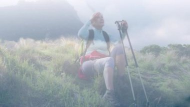 Hızlı hareket eden bulutların üzerinde dağlarda yürürken dinlenen Kafkasyalı son sınıf öğrencisi mutlu kadın. etkin emeklilik yaşam tarzı konsepti dijital olarak oluşturulmuş video.