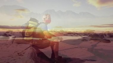 Kafkas kıdemli adam kıyı boyunca hızlı hareket eden bulutların üzerinde yürüyüş yapıyor. Coronavirus covide 19 pandemik konsept dijital olarak oluşturulmuş video sırasında aktif emeklilik yaşam tarzı.