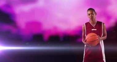 Afro-Amerikan bayan basketbolcunun animasyonu. Bulutlu pembe ve ışıklı topu var. Fotokopi alanı olan profesyonel spor şablonu konsepti, dijital olarak oluşturulmuş video.