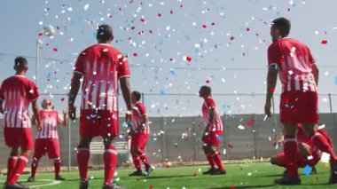 Çim tarlasında antrenman yapan erkek futbolculara karşı renkli bir konfeti düştü. spor ve teknoloji konsepti