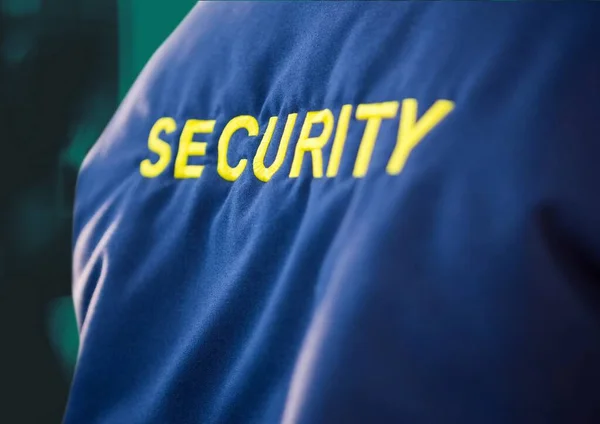 緑の背景に黄色のテキストとセキュリティガードブルージャケットの中央部の構成 セキュリティと安全の概念がデジタルで生成され — ストック写真