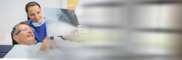 Samenstelling Van Lachende Vrouwelijke Tandarts Mannelijke Patiënt Zoek Naar Röntgenfoto — Stockfoto