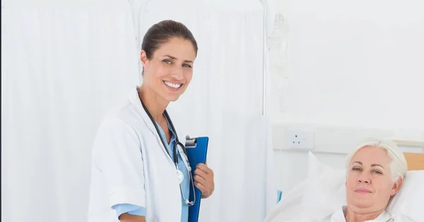 Retrato Doctora Caucásica Sosteniendo Portapapeles Sonriendo Mientras Paciente Cama Hospital —  Fotos de Stock