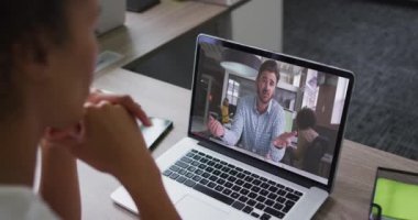 Afrika kökenli Amerikalı bir kadın, erkek meslektaşı ile bilgisayarında video görüşmesi yapıyor. iş, profesyonellik ve ofis kavramı