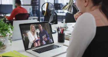 Beyaz bir kadın, erkek ve bayan ofis arkadaşlarıyla iş yerinde bilgisayar başında video görüşmesi yapıyor. iş, profesyonellik ve ofis kavramı