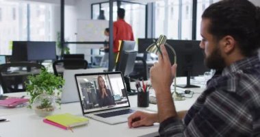 Ortadoğulu bir adam, ofisteki kadın meslektaşıyla görüntülü konuşma yapıyor. iş, profesyonellik ve ofis kavramı