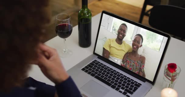 自宅のノートパソコンでビデオ通話をしながら アフリカ系アメリカ人女性がワインを飲んでいる 隔離されたまま家にいると — ストック動画
