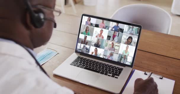 Médico Afroamericano Tomando Notas Mientras Hace Una Videoconferencia Portátil Concepto — Vídeo de stock