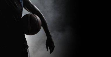 Siyah arka planda sigara içen atletik erkek basketbolcunun kompozisyonu. spor, fitness ve aktif yaşam tarzı konsepti dijital olarak oluşturulmuş görüntü.