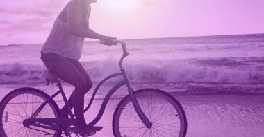 Plajda ışık bulanıklığının üstünde formda bir kadın bisikletçinin kompozisyonu. spor, fitness ve aktif yaşam tarzı konsepti dijital olarak oluşturulmuş görüntü.