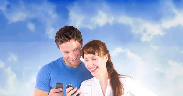 Композиция Счастливой Пары Улыбающейся Глядя Свои Смартфоны Над Голубым Облачным — стоковое фото