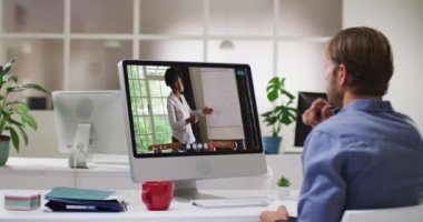 Beyaz bir adam, iş yerinde dizüstü bilgisayarında bayan meslektaşıyla görüntülü görüşme yapıyor. iş, profesyonellik ve ofis kavramı