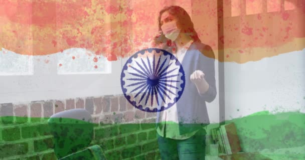インドの旗の上にフェイスマスクを身に着けている女性の構成 世界的なコロナウイルスのパンデミックとインドの医療危機の概念デジタルで生成されたビデオ — ストック動画