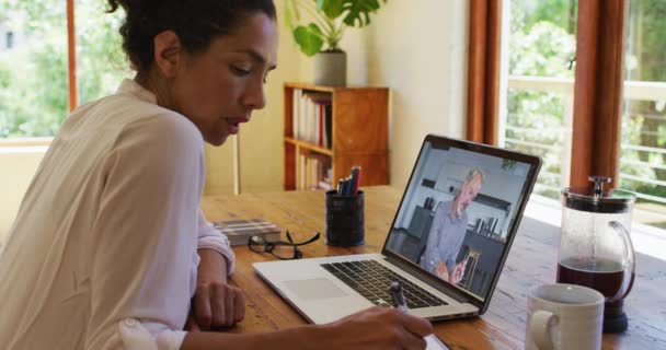 Afrikansk Amerikansk Kvinne Tar Notater Mens Hun Har Videosamtale Laptop – stockvideo