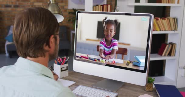 白人男性教師はアフリカ系アメリカ人の少女とコンピュータでビデオ通話をしながらメモを取る 遠隔教育とオンライン教育の概念は — ストック動画
