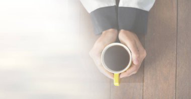 Ahşap yüzeyde, üzerinde fotokopi alanı olan sarı kahve fincanı tutan kadın kompozisyonu. içki ve kafein konsepti dijital olarak oluşturulmuş görüntü.