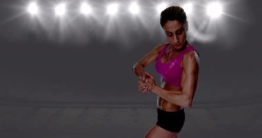 Pembe bluzlu güçlü kaslı kadın ve spot ışıklarının üzerinde siyah şort. spor ve spor konsepti dijital olarak oluşturulmuş video.