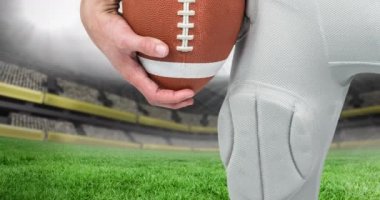 Futbol stadyumunun üzerinde top tutan rugby oyuncusunun orta bölümünün animasyonu. Spor etkinliği ve yarışma konsepti dijital olarak oluşturulmuş video.