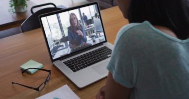 Afrika kökenli Amerikalı bir kadının kadın meslektaşıyla bilgisayarında görüntülü konuşma yapması. iş, profesyonellik ve teknoloji kavramı