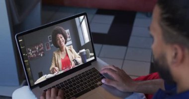 Ortadoğulu bir adam dizüstü bilgisayarında bayan meslektaşıyla görüntülü görüşme yapıyor. iş, profesyonellik ve teknoloji kavramı