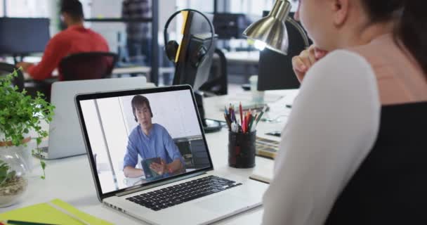 オフィスのノートパソコンで男性同僚とビデオ通話をしている白人女性 ビジネス プロ意識 オフィスのコンセプト — ストック動画