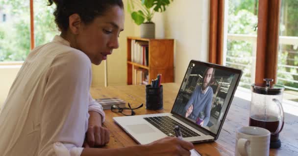 Mujer Afroamericana Tomando Notas Mientras Recibe Videollamadas Con Colega Varón — Vídeo de stock