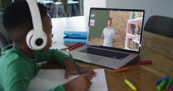 非洲裔美国男孩一边做作业 一边在家里用笔记本电脑与男教师进行视频通话 远程学习和网上教育概念 — 图库视频影像