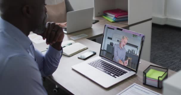 Der Afroamerikanische Geschäftsmann Sitzt Schreibtisch Und Telefoniert Laptop Mit Einem — Stockvideo