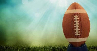 Sahnede ragbi topunun kompozisyonu fotokopi alanı ve yeşil arka planda ışık lekeleri. spor ve yarışma konsepti dijital olarak oluşturulmuş görüntü.