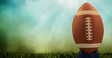 Sahada rugby topu kompozisyonu ve mavi zemin üzerinde ışık lekeleri var. spor ve yarışma konsepti dijital olarak oluşturulmuş görüntü.