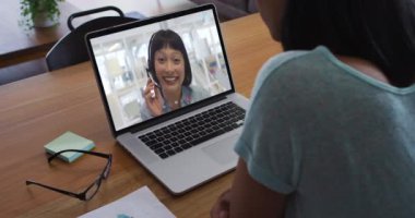 Afrika kökenli Amerikalı bir kadının kadın meslektaşıyla bilgisayarında görüntülü konuşma yapması. iş, profesyonellik ve teknoloji kavramı