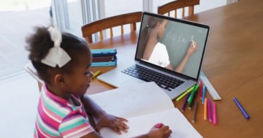 İnternetten ders alan Afrikalı Amerikalı bir kız dizüstü bilgisayar kullanıyor. Karantina süresince evde tecrit altında..