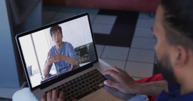 Orta Doğulu bir adam, erkek iş arkadaşıyla bilgisayarında video görüşmesi yapıyor. iş, profesyonellik ve teknoloji kavramı