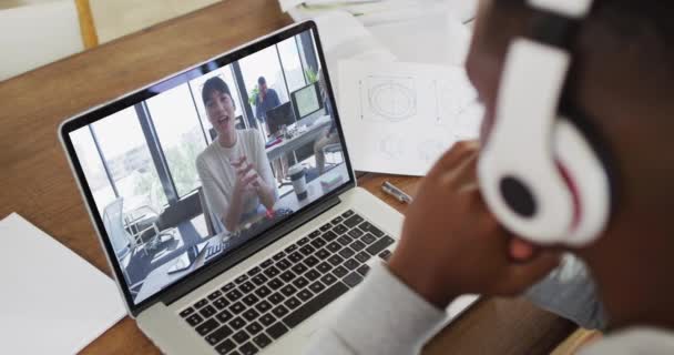 アフリカ系アメリカ人男性大学生がノートを持ちながら 自宅のノートパソコンでビデオ通話をしている 遠隔教育とオンライン教育の概念は — ストック動画