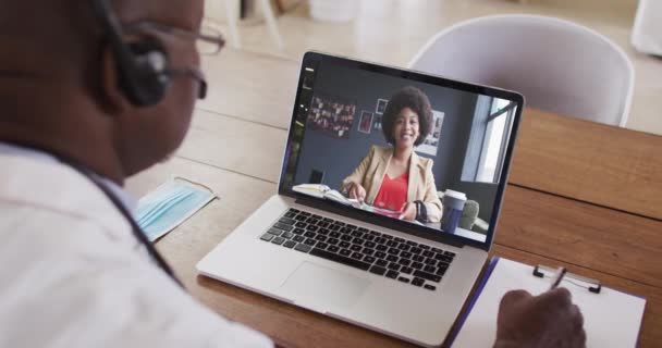 Afrikanisch Amerikanischer Arzt Mit Kopfhörer Der Notizen Macht Während Einen — Stockvideo