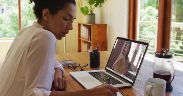 Afroamerykanka Robi Notatki Podczas Rozmowy Wideo Koleżanką Laptopie Domu Praca — Wideo stockowe
