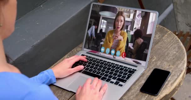 女性同僚とビデオ通話をするラップトップを使用してデスクに座っている白人の実業家 オンライン会議隔離中の隔離作業 — ストック動画