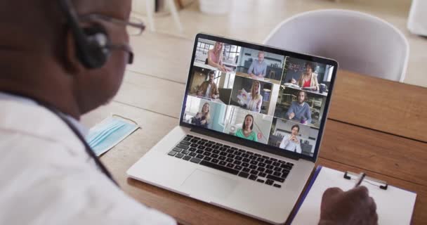 아프리카 미국인 의사가 노트북으로 비디오 컨퍼런스를 필기를 있습니다 원거리 — 비디오