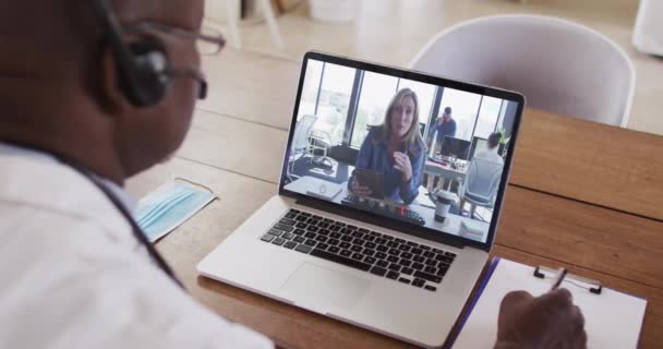 Afro Amerikaanse Mannelijke Arts Draagt Een Telefoon Headset Neemt Notities — Stockvideo