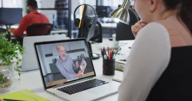 Beyaz bir kadın, erkek meslektaşı ile bilgisayarında video görüşmesi yapıyor. iş, profesyonellik ve teknoloji kavramı
