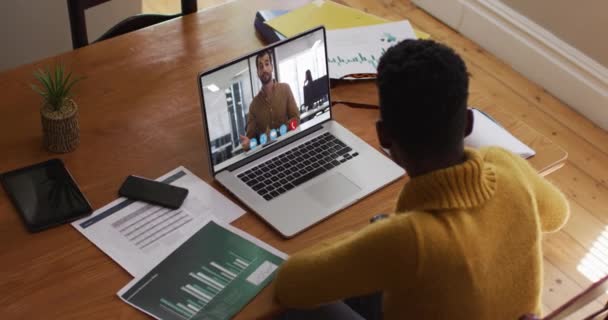 アフリカ系アメリカ人のビジネスマンは 同僚とビデオ通話をするラップトップを使用してデスクに座っています オンライン会議隔離中の隔離作業 — ストック動画