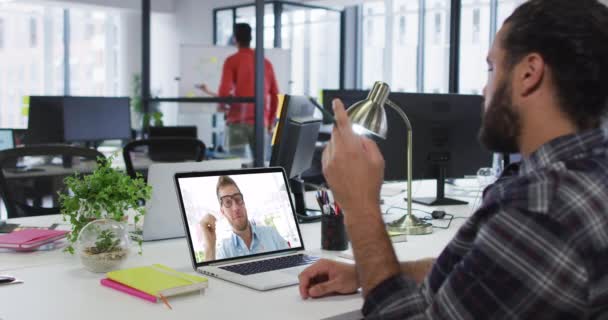 中東の男はオフィスのノートパソコンで男性の同僚とビデオ通話をしています ビジネス プロ意識 テクノロジーの概念 — ストック動画