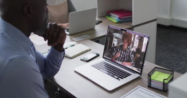 Afroamerykanin Starszy Mężczyzna Rozmawia Przez Telefon Kolegą Laptopie Biurze Koncepcja — Wideo stockowe